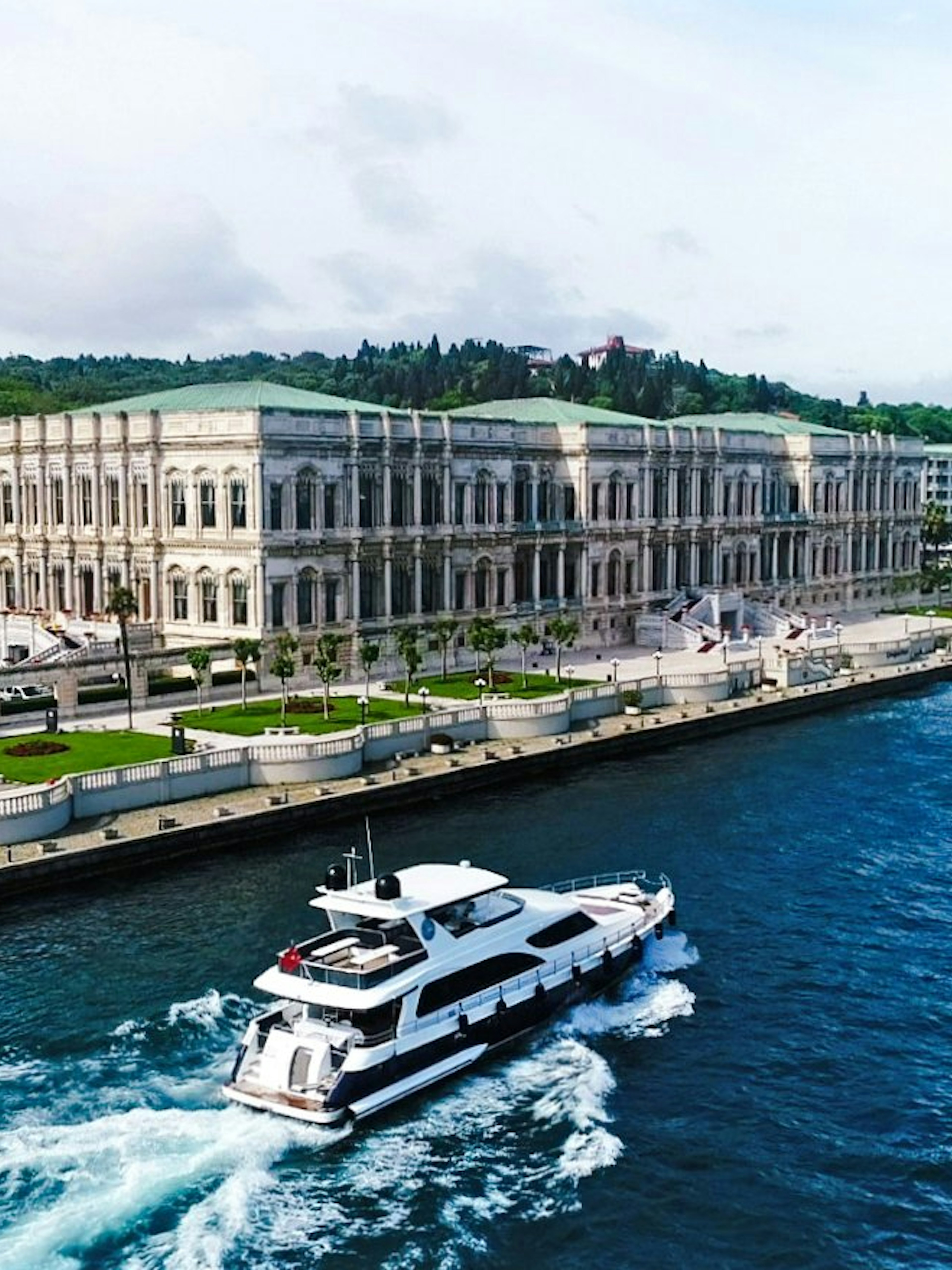 Yacht cruising past Çırağan Palace on the Bosphorus, Istanbul.