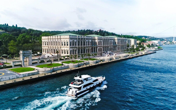 Yacht cruising past Çırağan Palace on the Bosphorus, Istanbul.