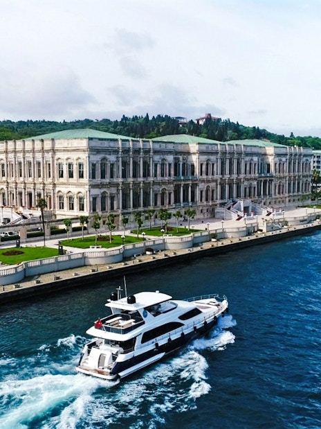 Yacht cruising past Çırağan Palace on the Bosphorus, Istanbul.