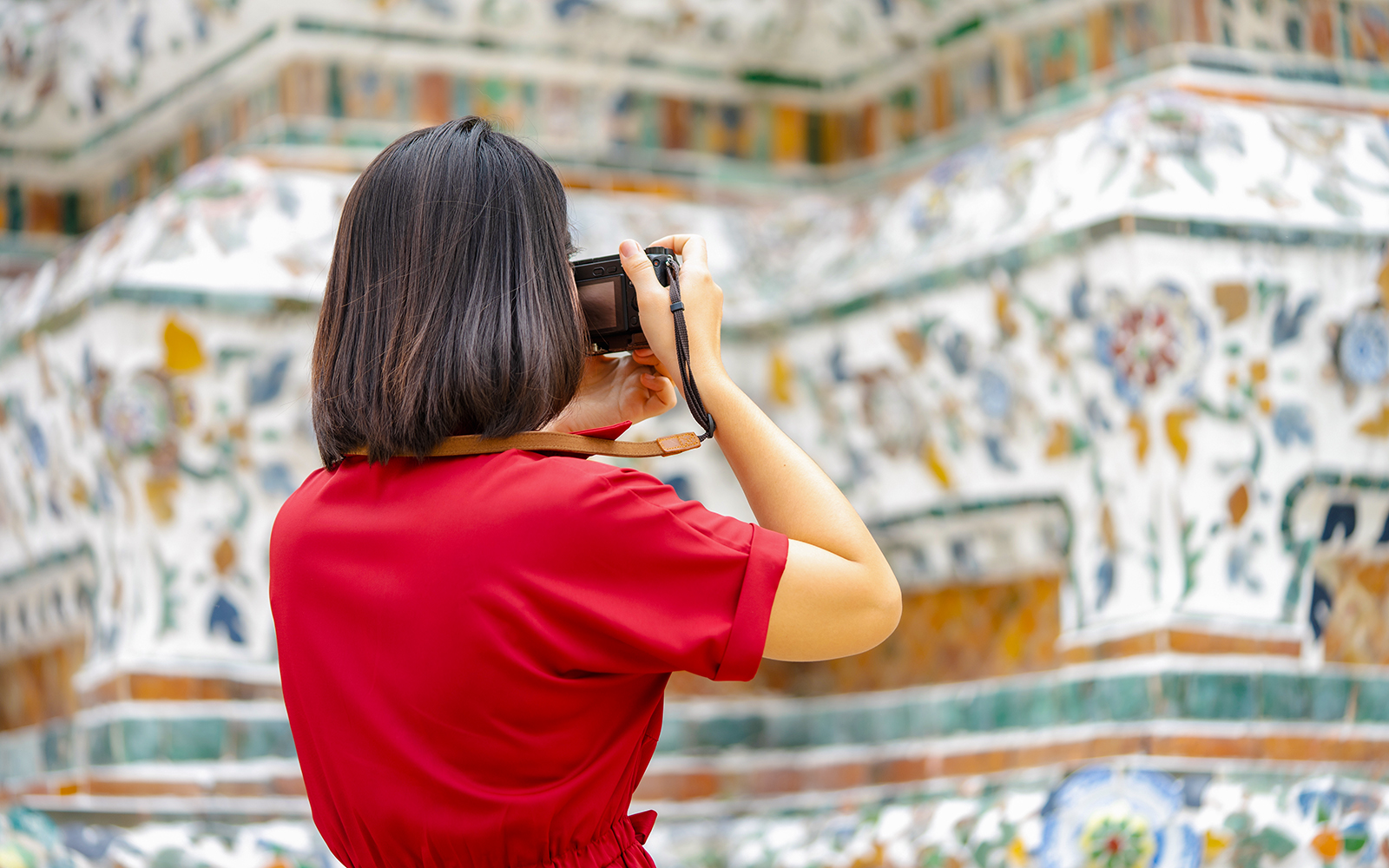 Tourist photographing Wat Arun temple in Bangkok.
