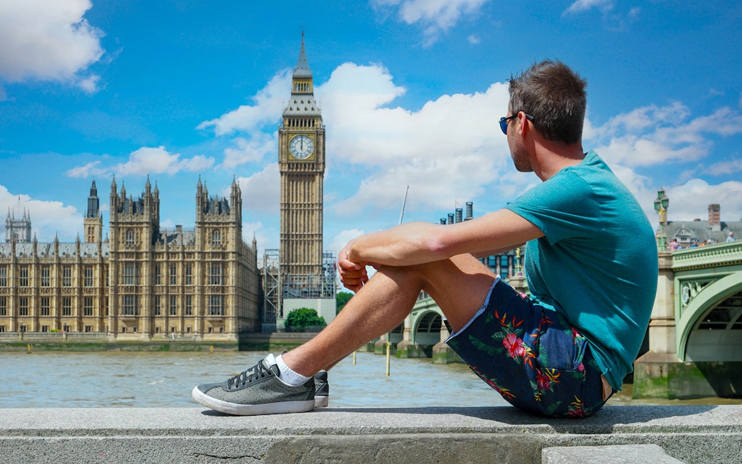 Man sitting near Big Ben, London, part of Harry Potter film locations tour.