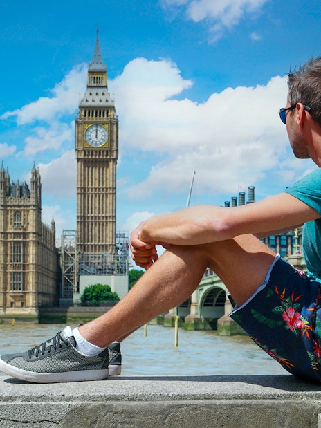 Man sitting near Big Ben, London, part of Harry Potter film locations tour.