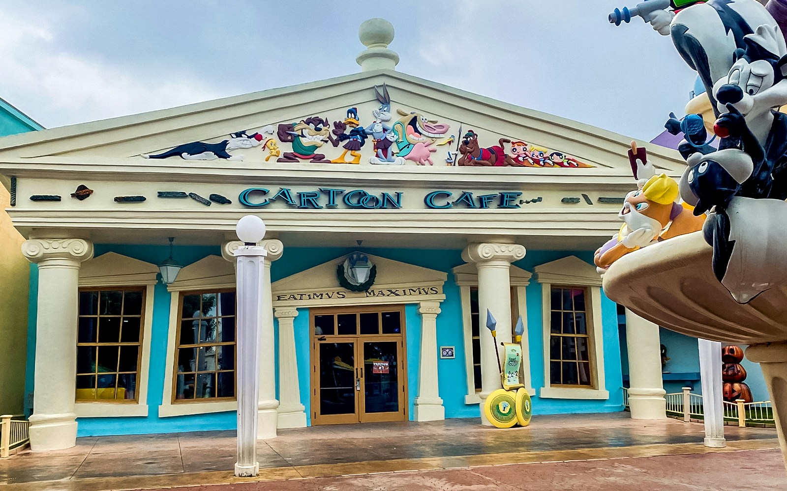 Themed cafe at Parque Warner Madrid with cartoon character decor and visitors dining.