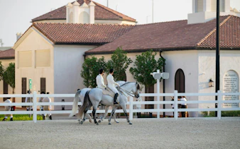 Equestrians riding horses at Abu Dhabi Royal Equestrian Arts venue.