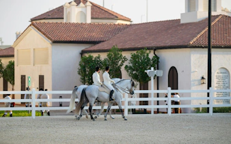 Equestrians riding horses at Abu Dhabi Royal Equestrian Arts venue.