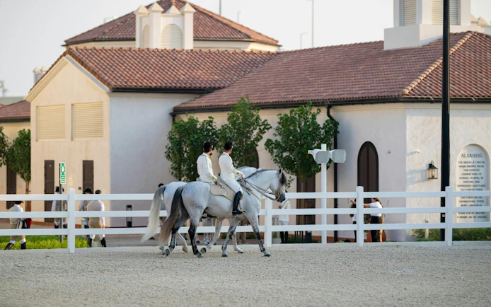 Equestrians riding horses at Abu Dhabi Royal Equestrian Arts venue.