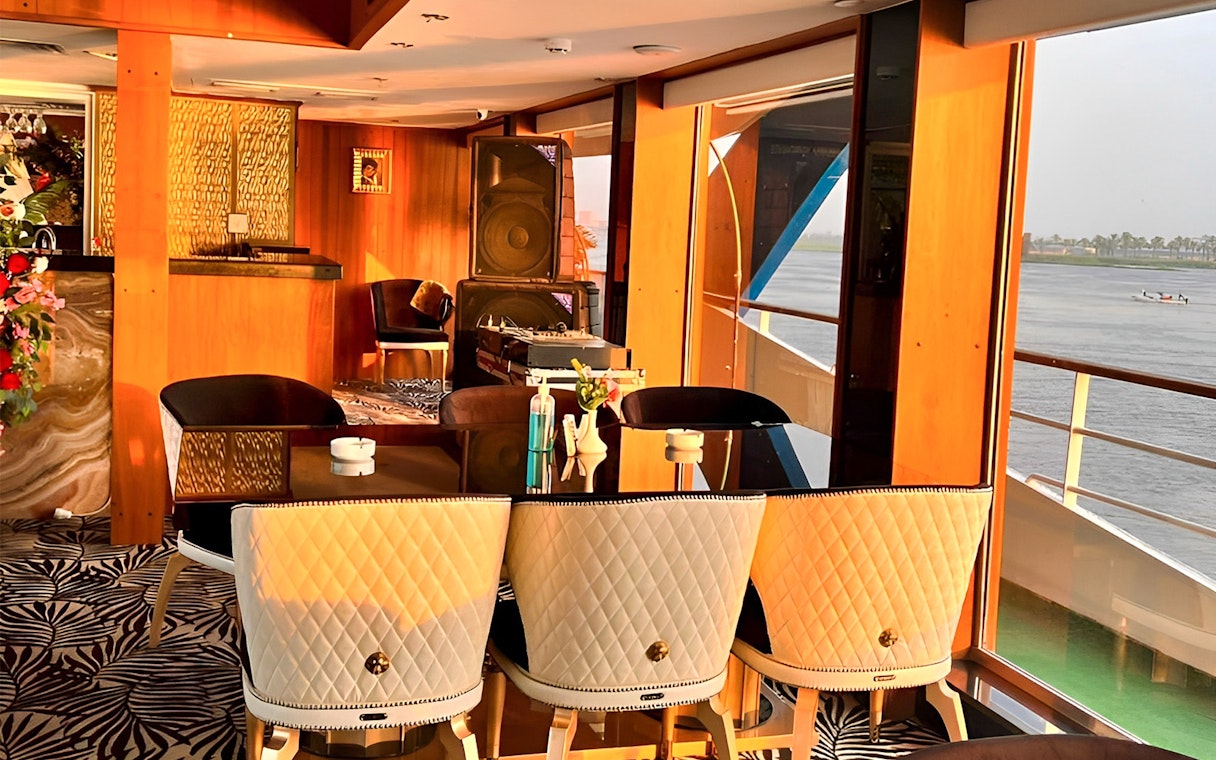 Dining area on a Nile dinner cruise ship in Cairo with river view.