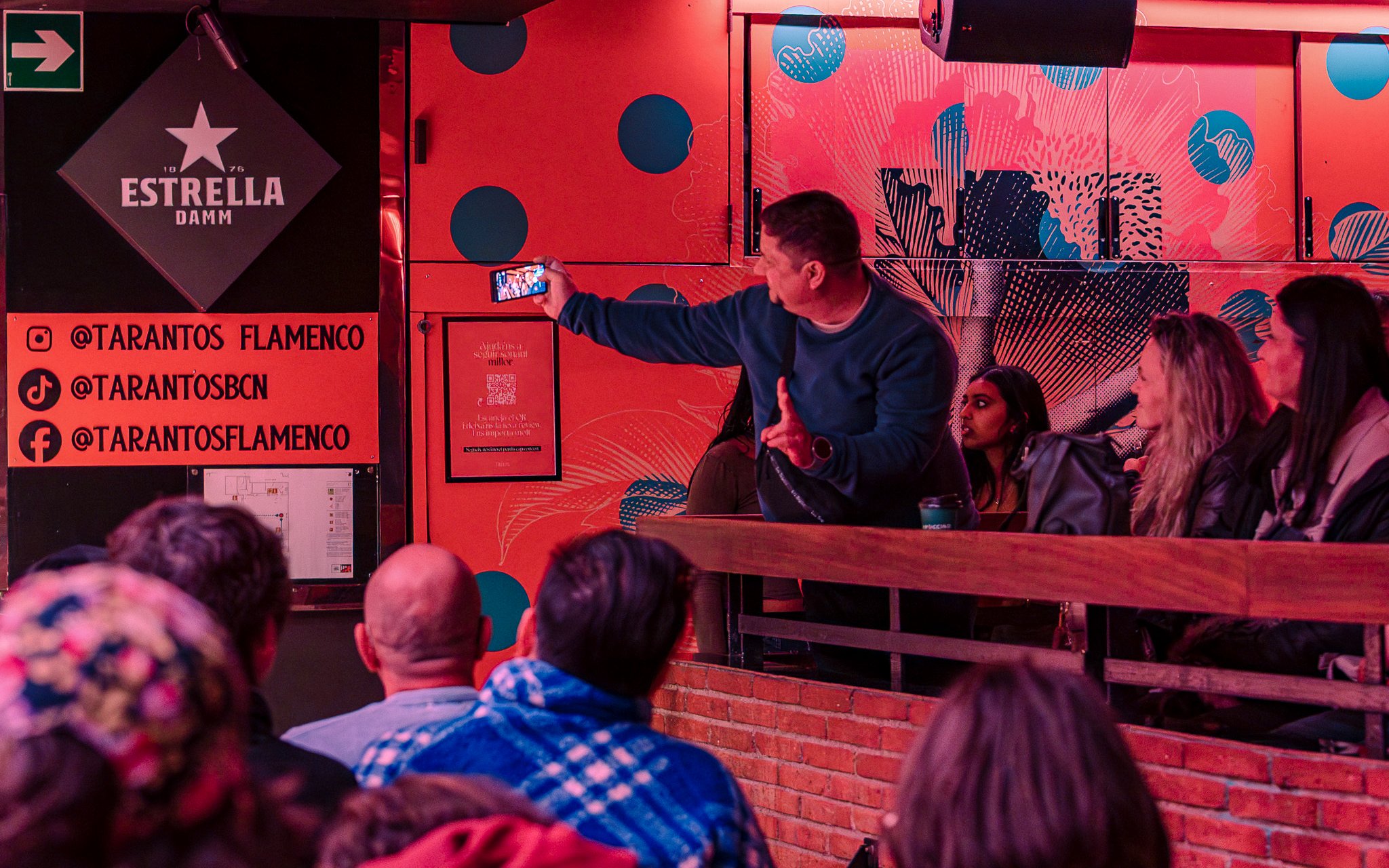 Audience at Los Tarantos Flamenco Show in Barcelona capturing the performance on a phone.