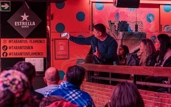 Audience at Los Tarantos Flamenco Show in Barcelona capturing the performance on a phone.