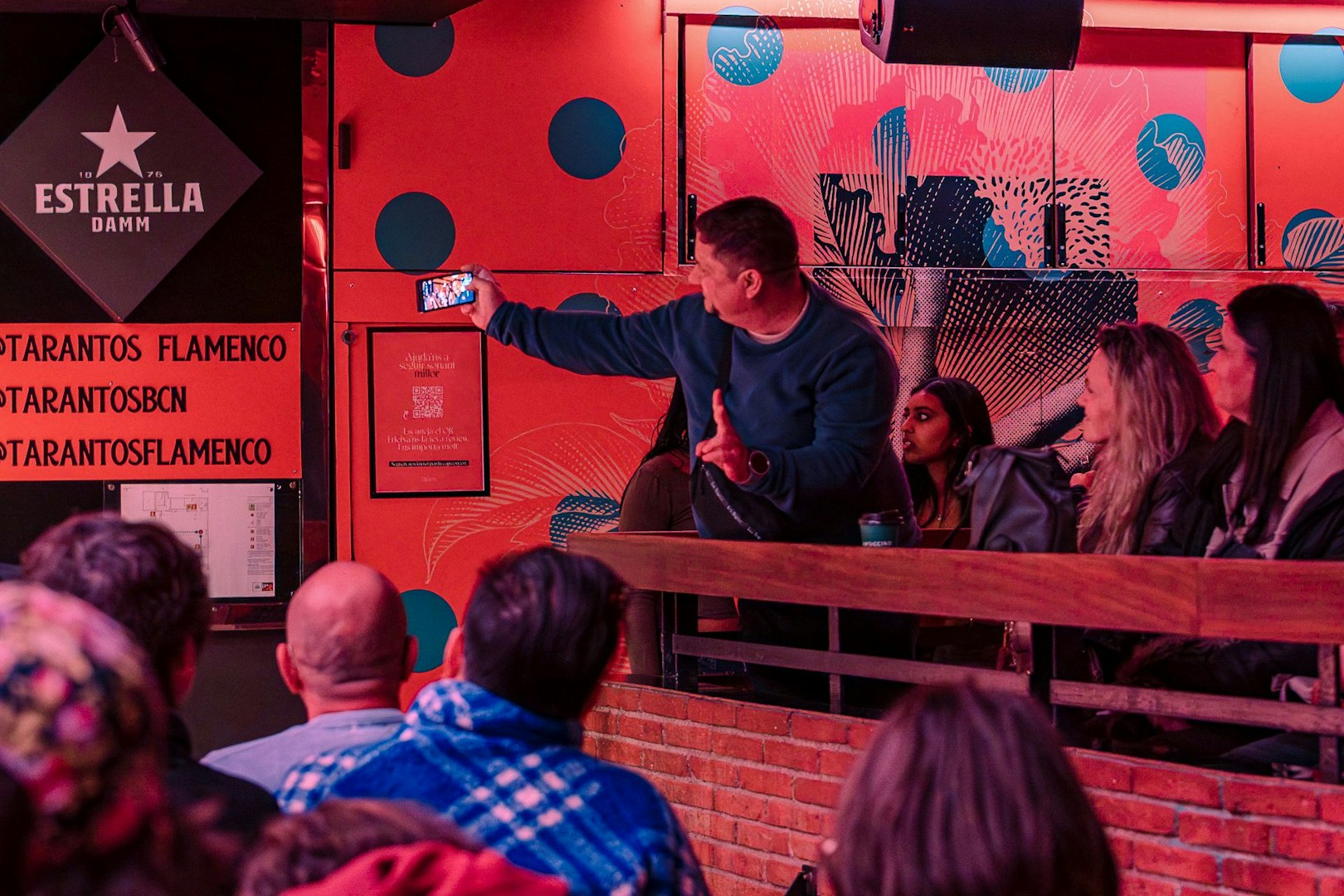 Audience at Los Tarantos Flamenco Show in Barcelona capturing the performance on a phone.