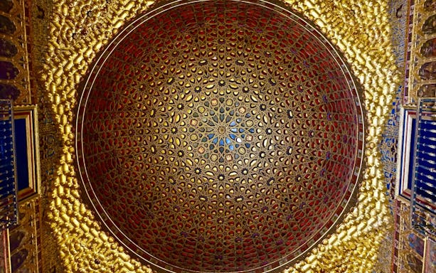 Ornate dome ceiling with intricate geometric patterns in Alcazar Seville.