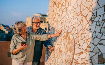 Couple exploring mosaic details on La Pedrera rooftop during sunset visit in Barcelona.