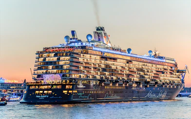 Large cruise ship illuminated at sunset during a 1.5h Grand Evening Lights Cruise.
