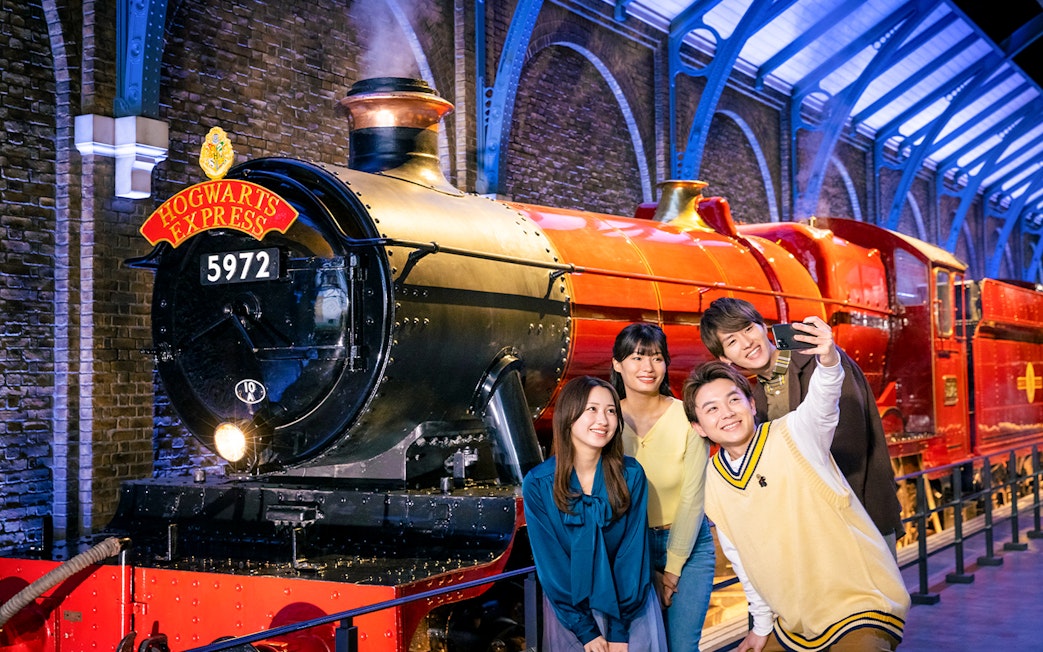 Group taking a selfie in front of Hogwarts Express at Warner Bros. Studio Tour Tokyo.