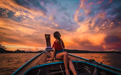Longtail boat at sunset on Krabi's 7 Islands tour with vibrant sky.