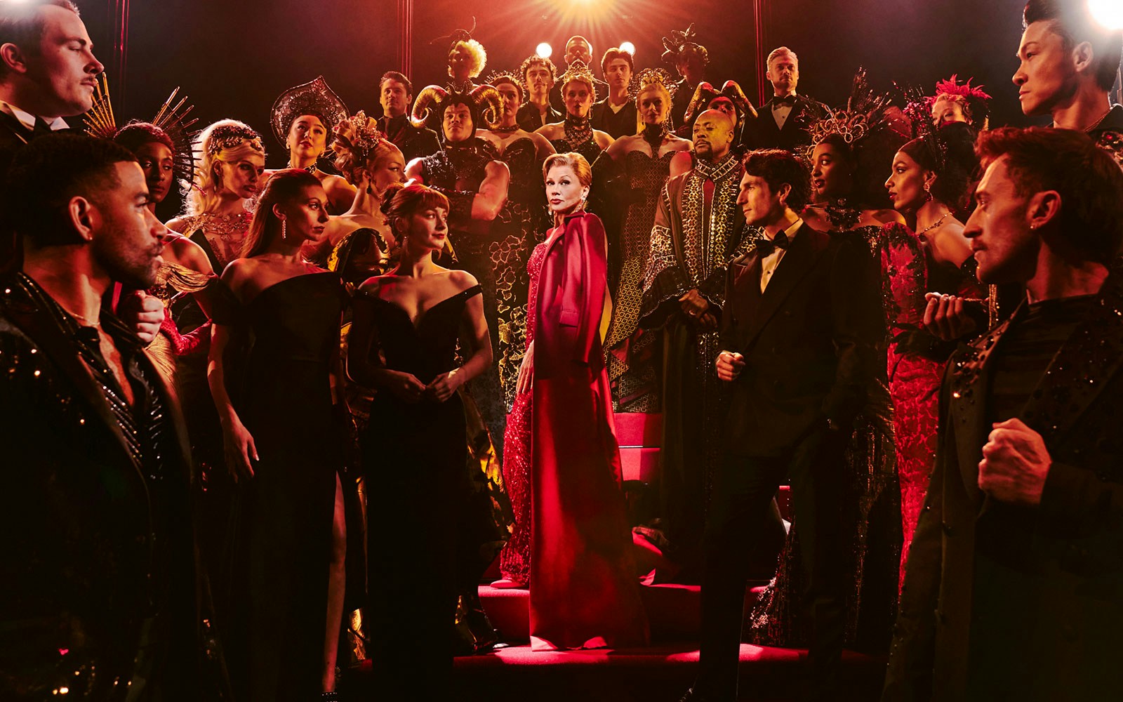 Cast of "The Devil Wears Prada" production in elaborate costumes on stage.