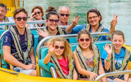 People smiling and waving on a Yellow Boats tour in Dubai.