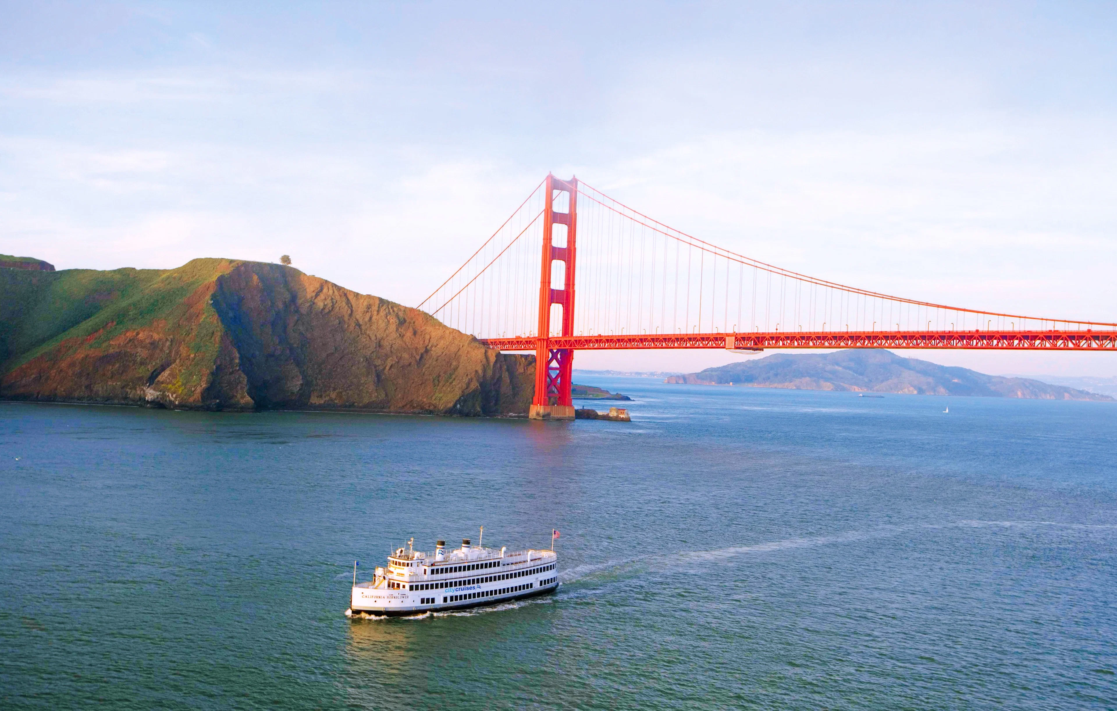 Cruise ship sailing under Golden Gate Bridge in San Francisco Bay.