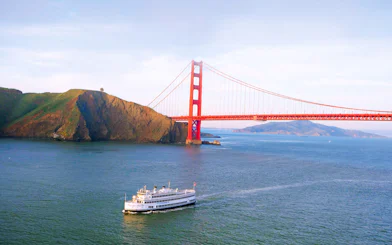 Cruise ship sailing under Golden Gate Bridge in San Francisco Bay.