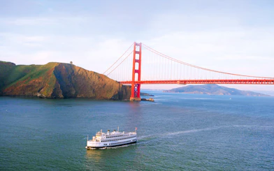 Cruise ship sailing under Golden Gate Bridge in San Francisco Bay.