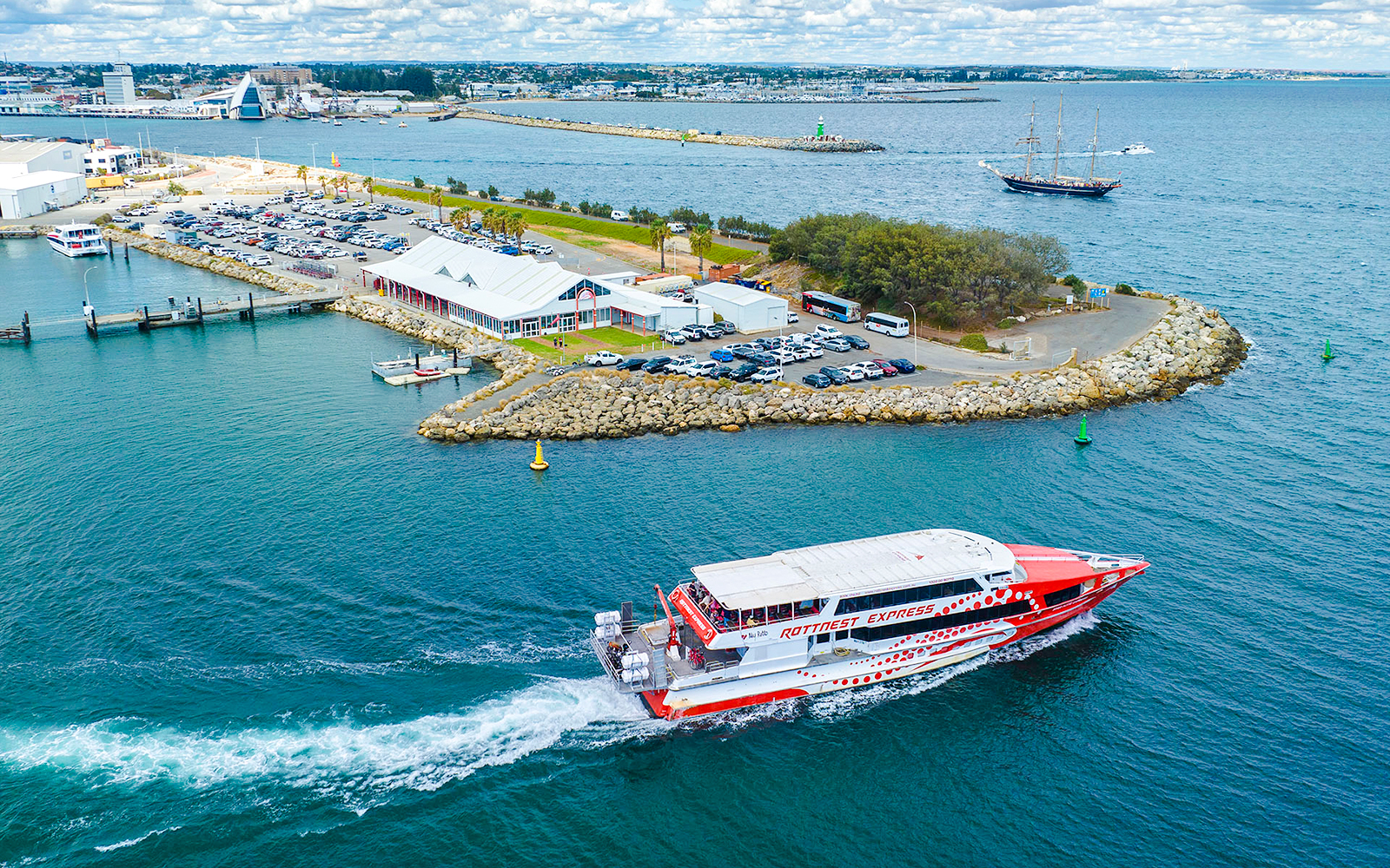 Rottnest Express ferry leaving jetty with cars and buildings in Fremantle, Australia.