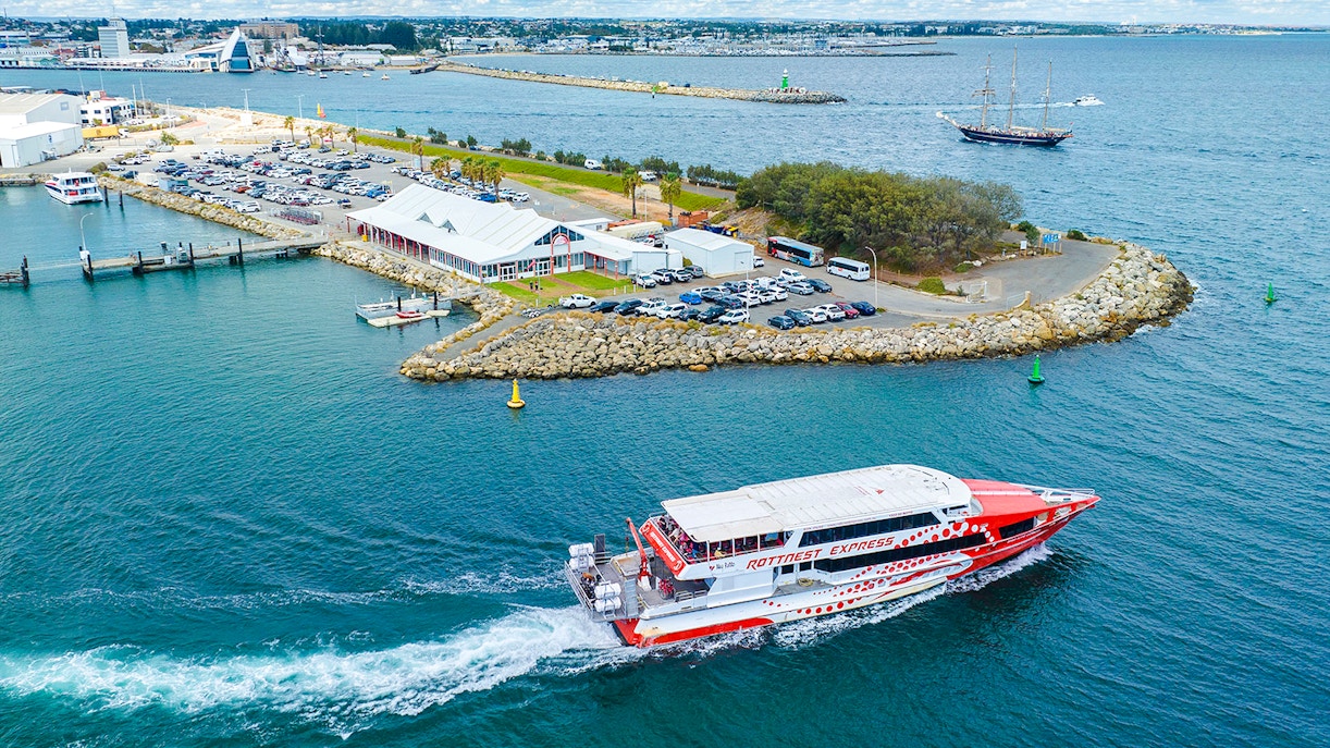 Rottnest Express ferry leaving jetty with cars and buildings in Fremantle, Australia.