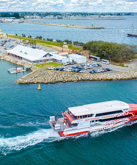 Rottnest Express ferry leaving jetty with cars and buildings in Fremantle, Australia.