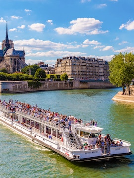 Bateaux Mouches cruise on the Seine near Notre Dame Cathedral, Paris.