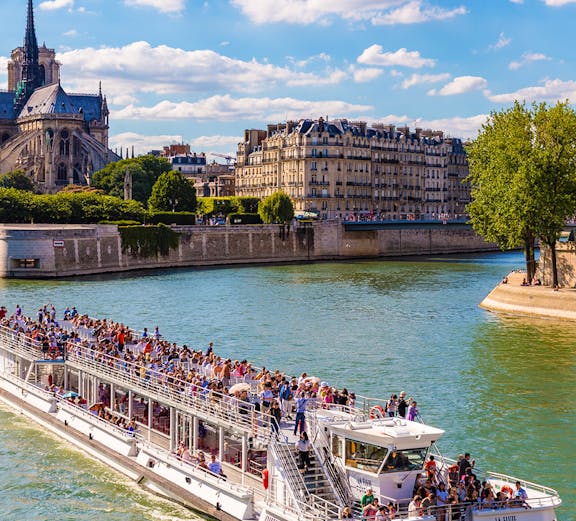 Bateaux Mouches cruise on the Seine near Notre Dame Cathedral, Paris.