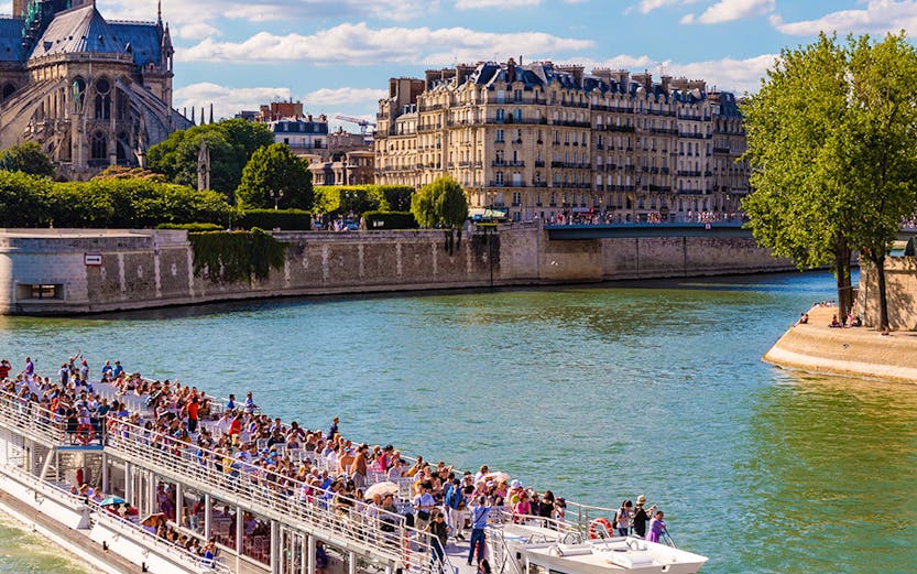 Bateaux Mouches cruise on the Seine near Notre Dame Cathedral, Paris.