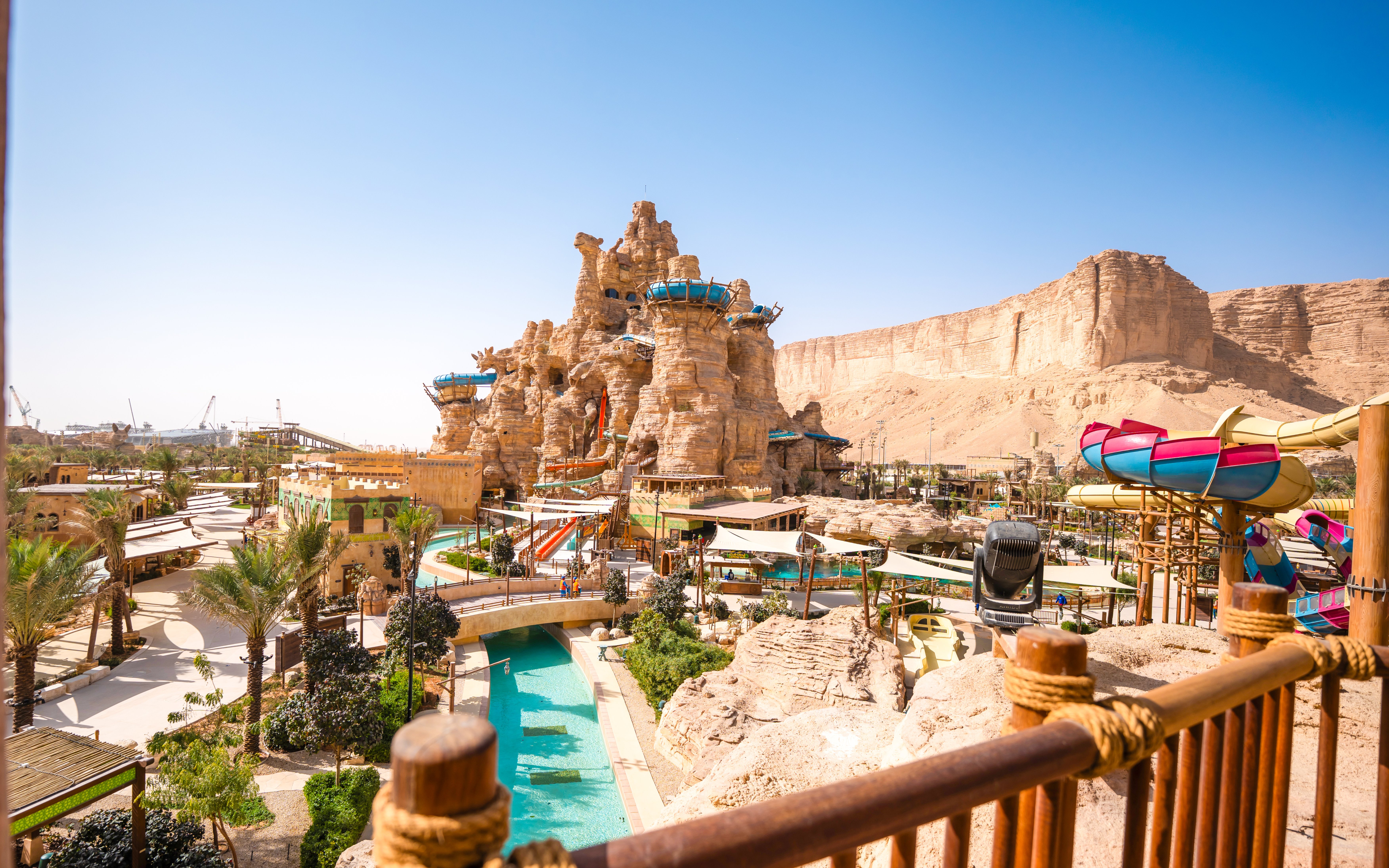 Wide view of water slides and rock formations at Aquarabia Qiddiya, Saudi Arabia.
