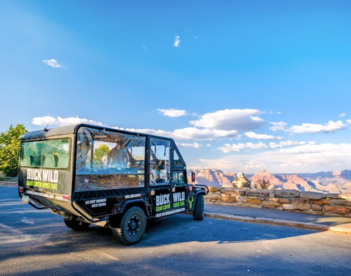 Hummer parked at Grand Canyon viewpoint with scenic canyon backdrop.