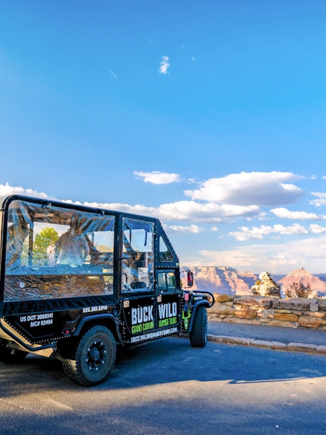 Hummer parked at Grand Canyon viewpoint with scenic canyon backdrop.