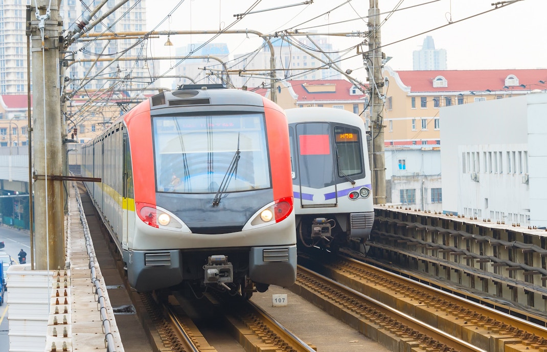 Shanghai metro trains on elevated tracks in urban area.