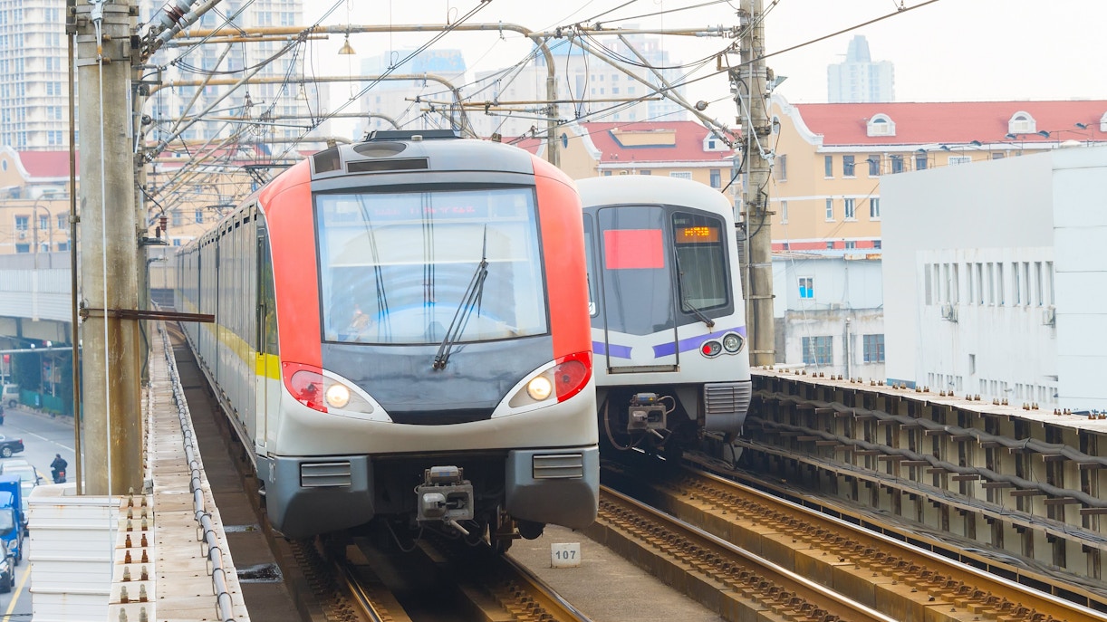 Shanghai metro trains on elevated tracks in urban area.