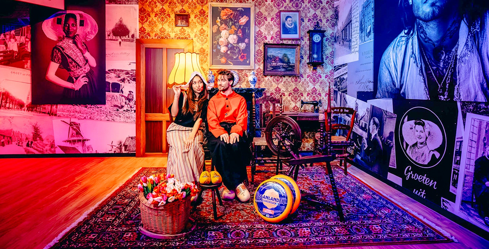 Guests in traditional Dutch attire at a Holland-themed exhibit with tulips and cheese.