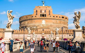 Visitors walking on the bridge towards Castel Sant'Angelo in Rome.