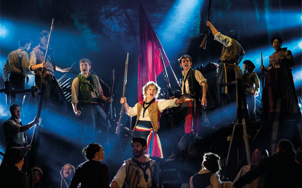 Actors performing a barricade scene in Les Miserables at Sondheim Theatre.