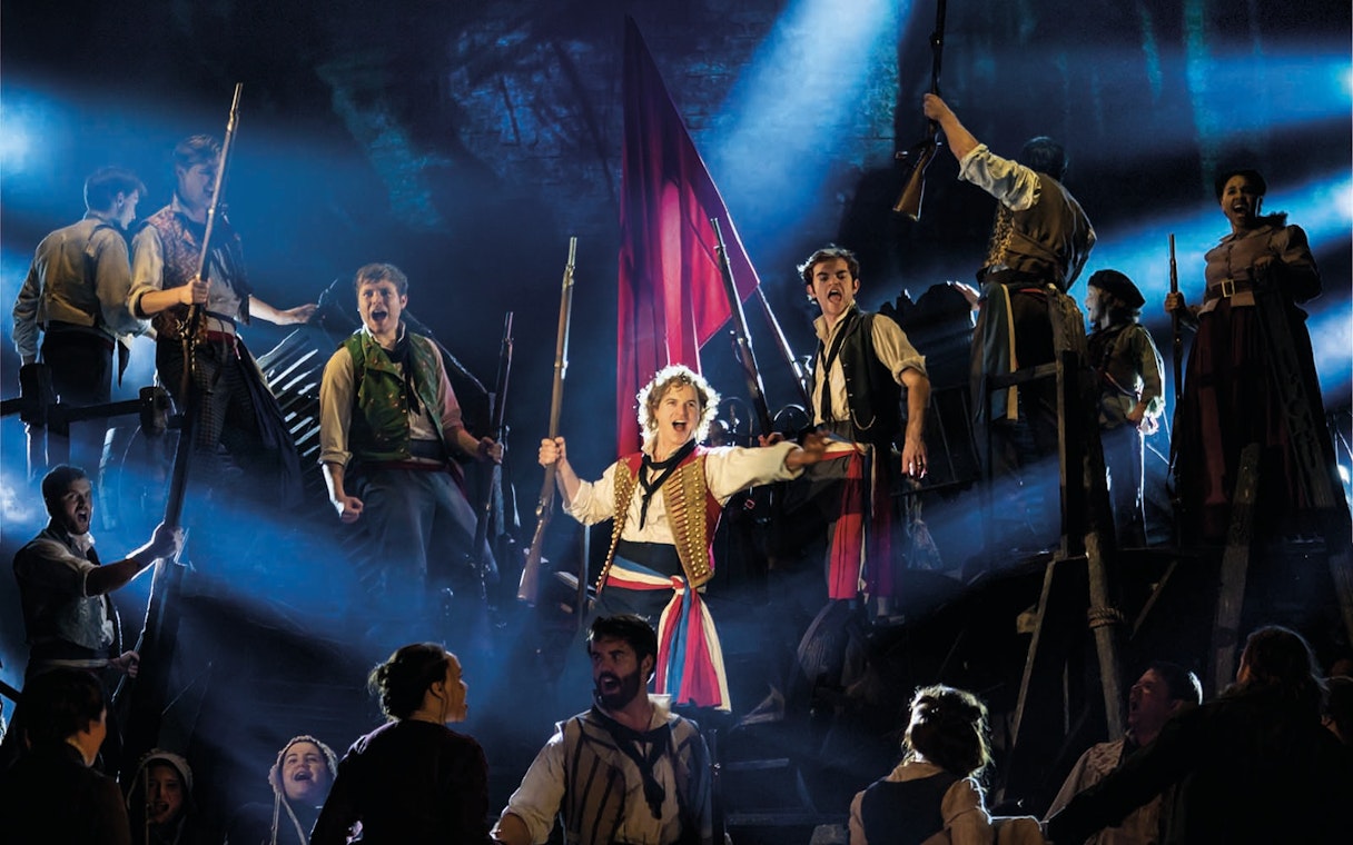 Actors performing a barricade scene in Les Miserables at Sondheim Theatre.