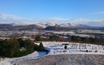 View from Stirling Castle ramparts overlooking snowy landscape and distant hills.