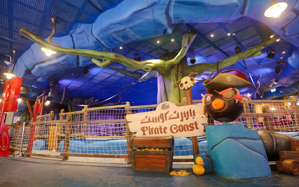 Pirate-themed ride entrance at Angry Birds World Theme Park, featuring a pirate bird statue and treasure chest.