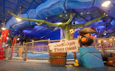 Pirate-themed ride entrance at Angry Birds World Theme Park, featuring a pirate bird statue and treasure chest.
