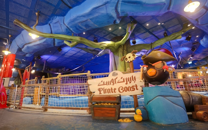 Pirate-themed ride entrance at Angry Birds World Theme Park, featuring a pirate bird statue and treasure chest.