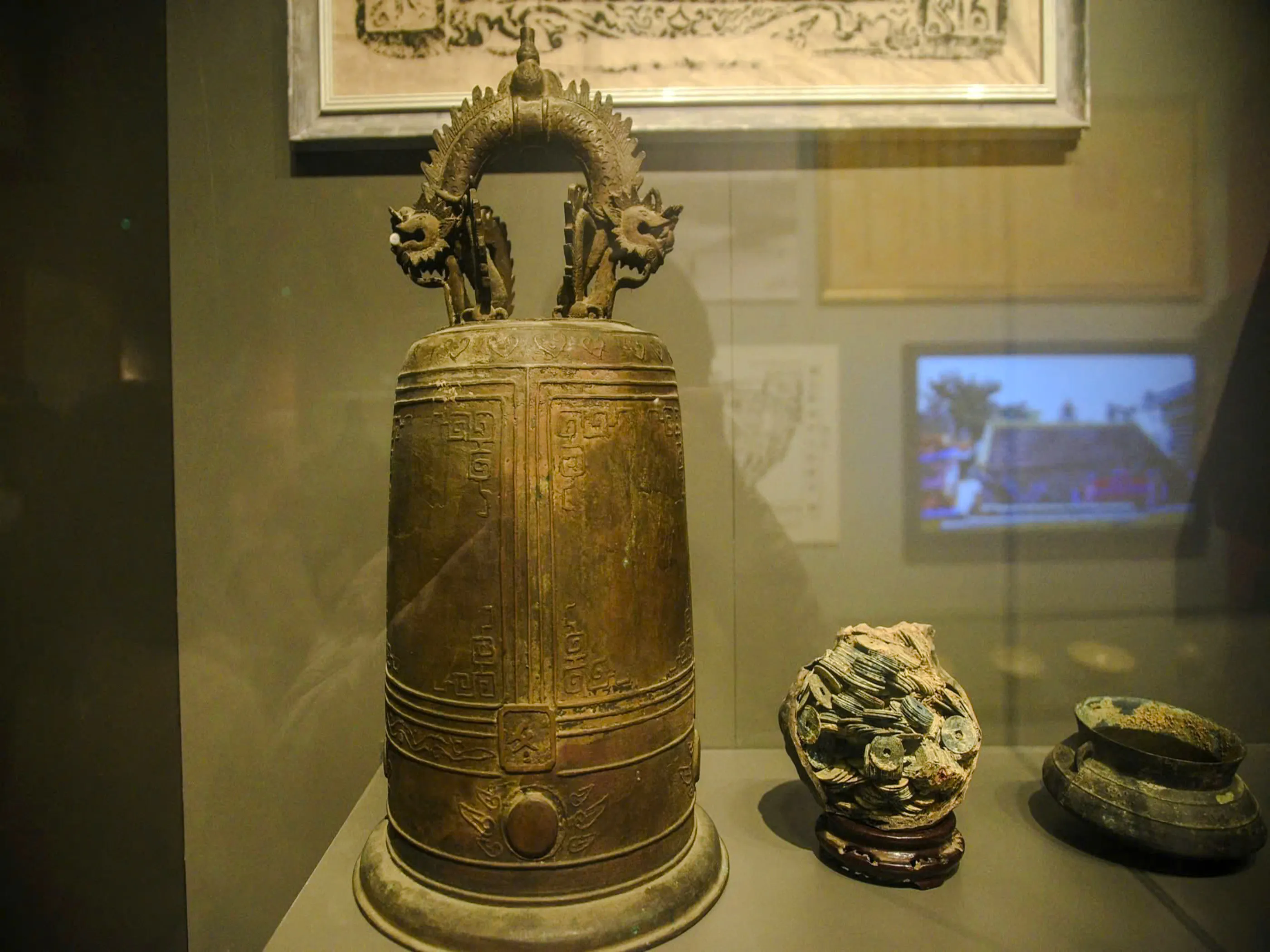 Ancient bronze bell with dragon motifs in Da Nang museum display.