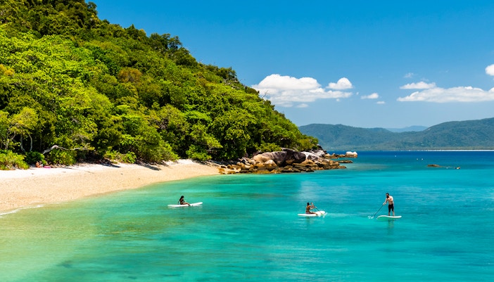 Group of tourists enjoying the Full Day Fitzroy Island Adventure Tour from Cairns, exploring the vibrant coral reefs and lush greenery of the island