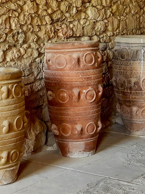 Ancient storage jars inside Knossos Palace, Crete, showcasing Minoan pottery design.