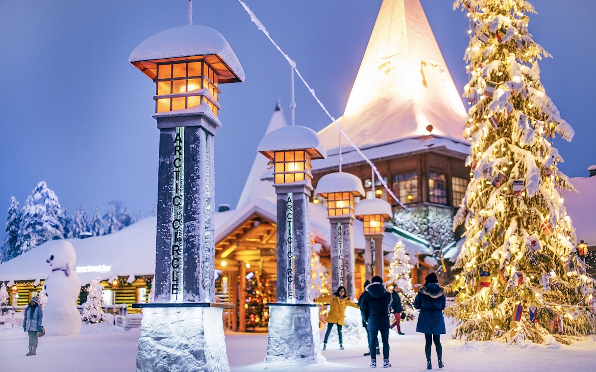Santa Claus Village entrance with snow-covered pillars and Christmas tree, Rovaniemi.