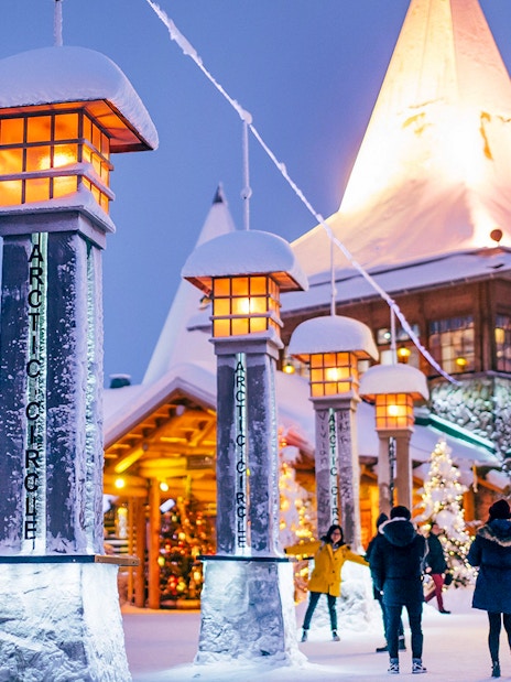 Santa Claus Village entrance with snow-covered pillars and Christmas tree, Rovaniemi.