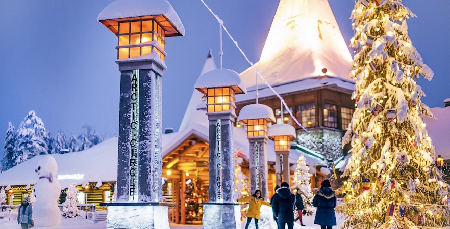 Santa Claus Village entrance with snow-covered pillars and Christmas tree, Rovaniemi.