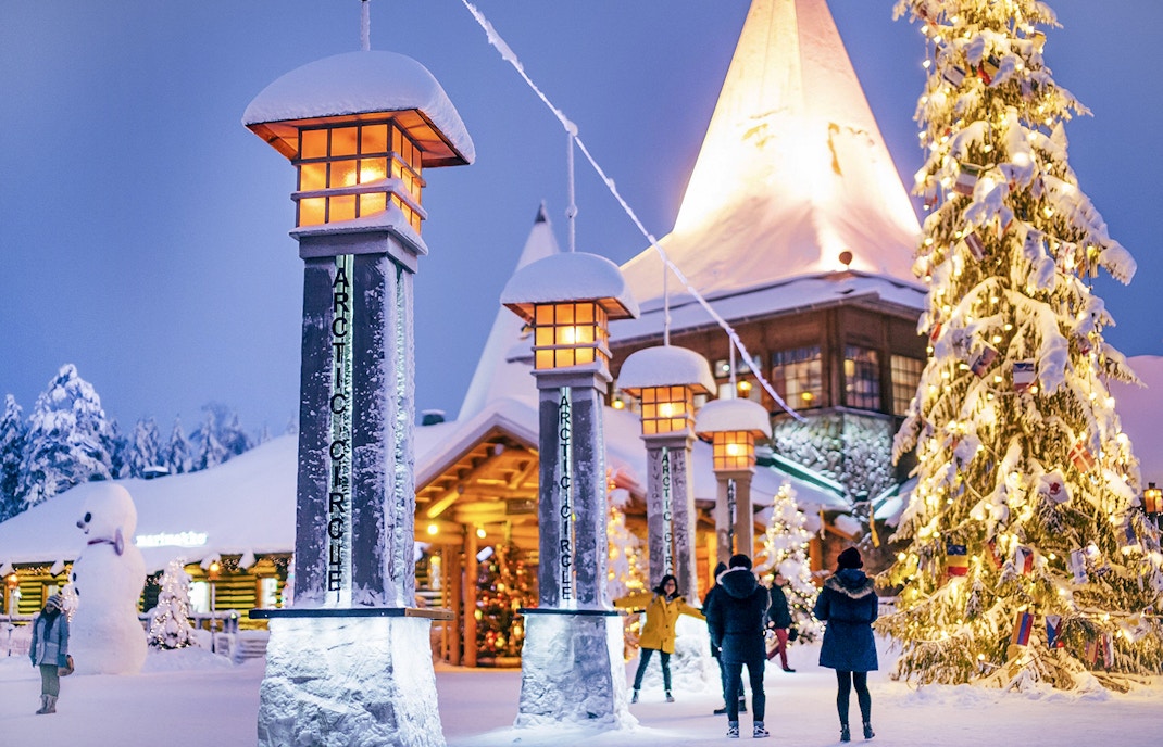 Santa Claus Village entrance with snow-covered pillars and Christmas tree, Rovaniemi.
